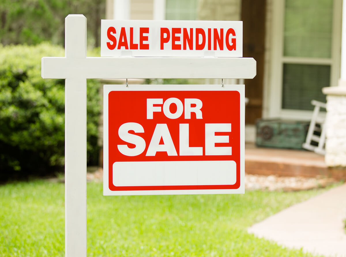 A For Sale sign outside a residential dwelling.