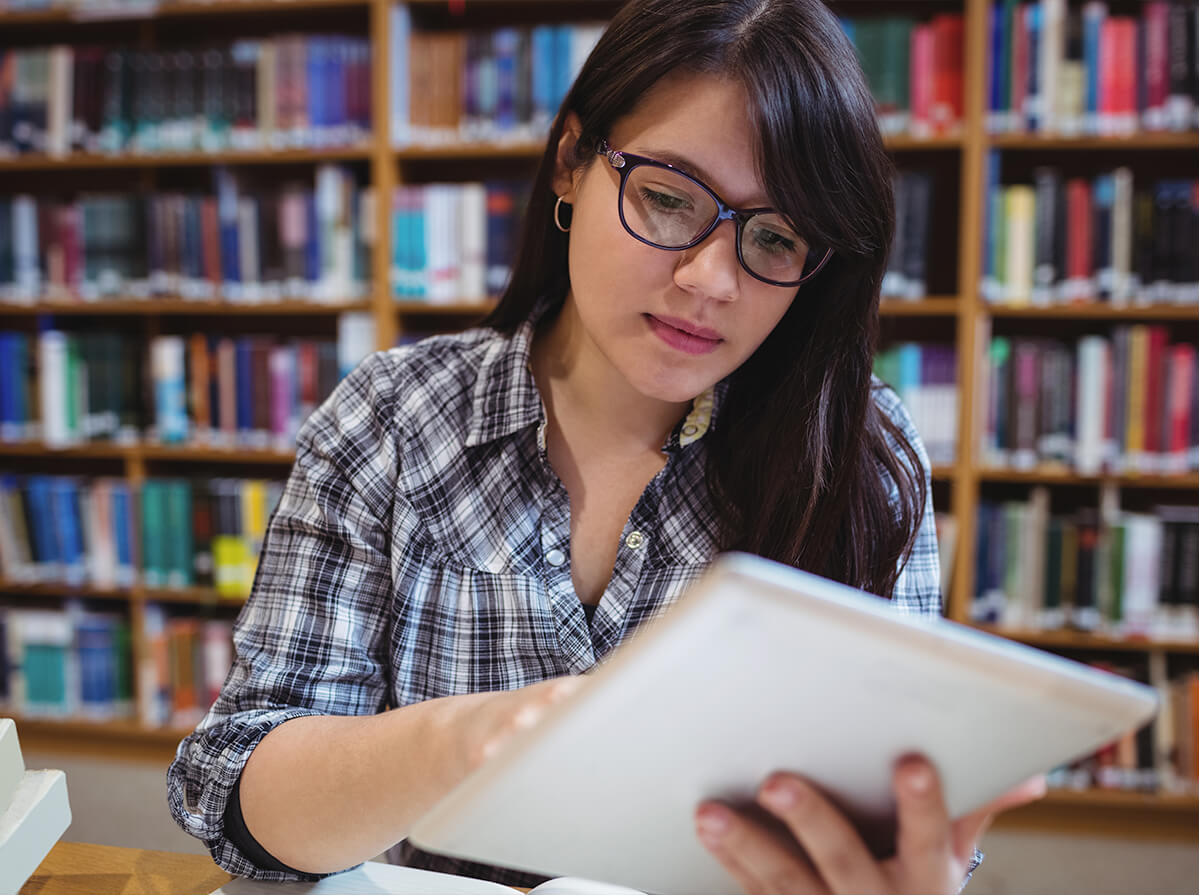 A student using her tablet in a library.