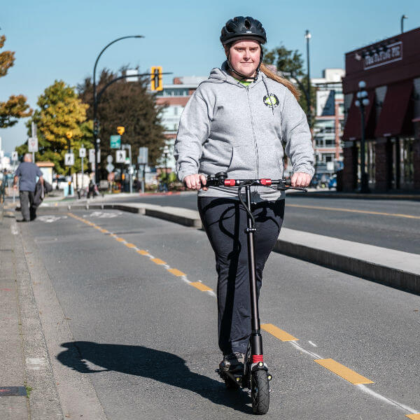woman riding electric scooter in bike lane
