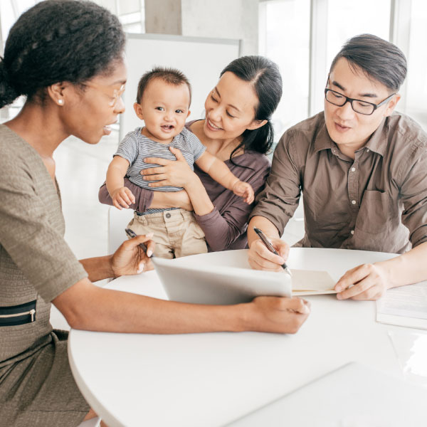 Family with small child looking over documents with another woman