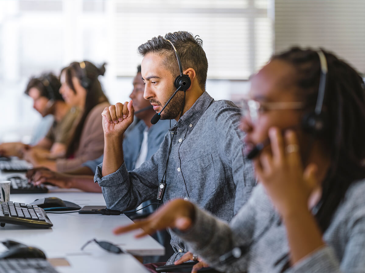 A row of people working at a call centre.